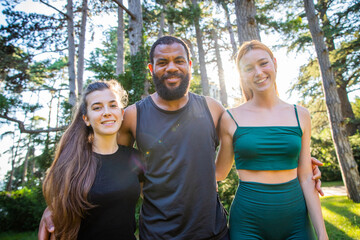 A group of smiling sportspeople during an outdoor workout in a park