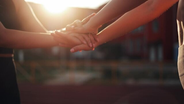 
Young female athletes after training, hands together and teamwork in stadium for support, cooperation and fitness, friends or people. A group of hands, a team, women with purpose, purpose and success