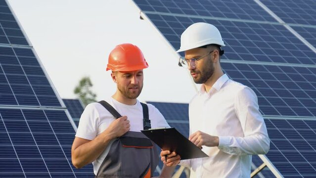 Two technical engineers review plan on paper and discuss