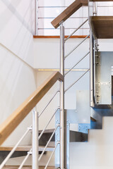 Fototapeta premium Modern design detail of metal and wood staircase in the interior of a bright house