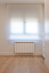 Naklejka na ściany i meble Interior of a bright room, plain wall with white window blind, white furniture, radiator and wooden floor. Interior, design, living concept