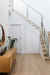 Image of a modern staircase in the foyer of a bright house interior decorated with wooden...