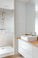 Luxury chrome shower, sink and mirror in modern marble bathroom with natural light for relaxing moments