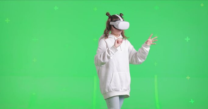 Shot on green screen background. VR or AR online at home. Cute girl in virtual reality googles. Woman turns around her axis while clicks invisible buttons and pulls virtual sliders. Internet fun.