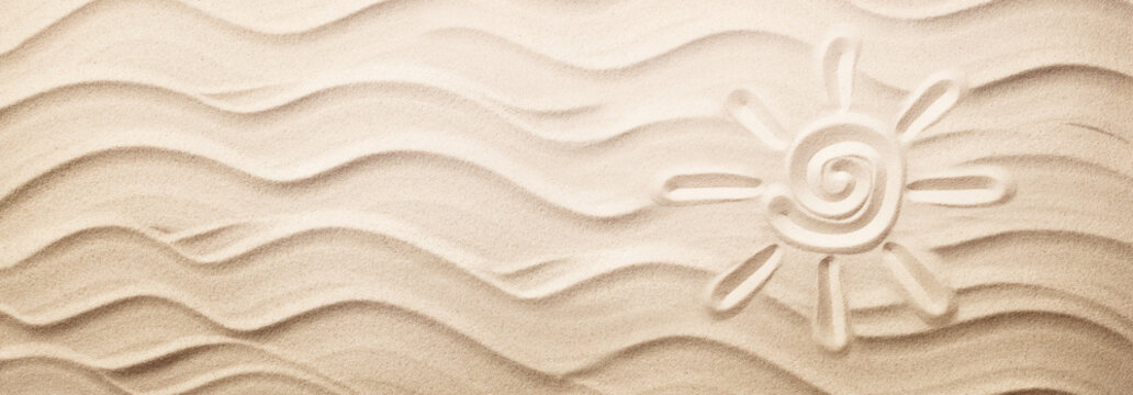 Simple sun drawing in the sand on the beach
