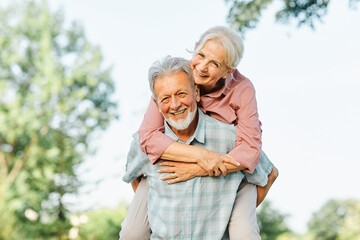 woman man outdoor senior couple happy lifestyle retirement together smiling love fun elderly active vitality nature mature portrait piggyback game - Powered by Adobe