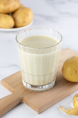 Vegan potato milk and potatoes on a white background. Plant-based lactose-free milk. Vegetable milk. 