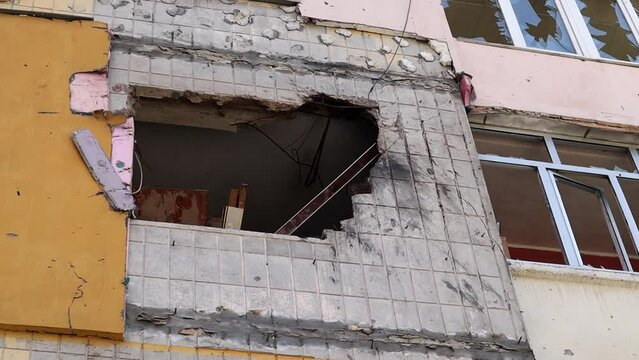 Traces of an artillery shell hitting a multi-storey residential building. Part of the building was destroyed by the shock wave and shrapnel. Shelling at home.