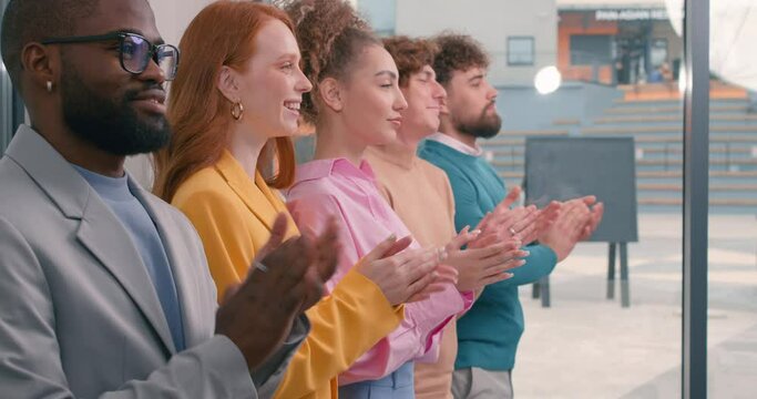 diverse mixed race group of business people standing in row clapping their hands Slow motion success Happiness Good job young men women greeting new colleagues, celebrating successful finished project