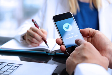 Business persons working  together in the office. Businessman showing a mobile phone with statement that payment sent