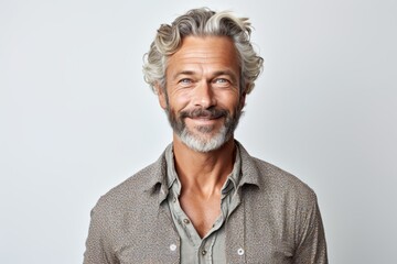 Portrait of handsome senior man with grey hair and beard smiling at camera
