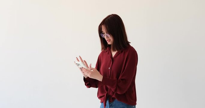 Caucasian teenage girl as she navigates through a white background while using her phone. In a state of stress and anxiety, she frantically attempts to undo a certain action on her device.