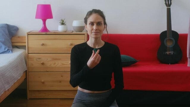 A female yoga instructor does an esoteric practice with crystals. Malachite is a copper carbonate hydroxide mineral. Female hands stretching green Malachite. Meditation with precious stones and