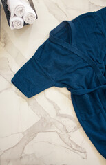 Minimal composition with a bathrobe and bath towels. A blue bathrobe on white background. Flat lay, top view, no people. Bath concept. 