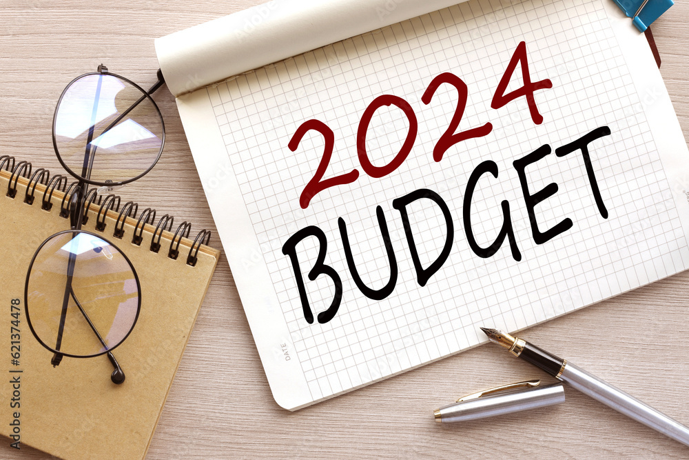 Poster budget 2024. top view of an open notebook with text. glasses near the notebook.close-up