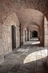 Оld historical vaulted hall in the interior of Castell de Montjuïc, Barcelona, Spain. View of the primitive Romanesque vault. Old military fortress