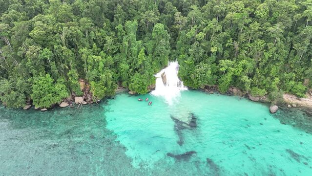 The beautiful Momon waterfall tumbles from the primordial rainforest of West Papua into the shallow sea. This spectacular waterfall is found about a day's sail north of Kaimana and Triton Bay.  