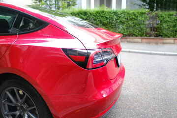 part of red electric car parked on street, taillights all-electric sedan, concept environmental minimizing, High Tech Technology