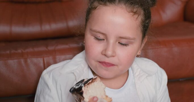 adorable funny cute girl enjoying eating cake and donut, looking at camera smiling with dirty teeth Happiness Childhood Slow motion