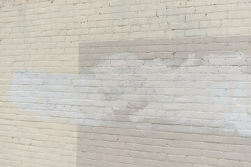 painted brick wall with efforts to remove graffiti 