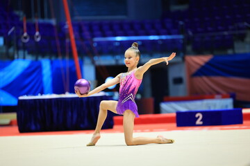 Little girl gymnast, performs various gymnastic and fitness exercises. The concept of childhood and...