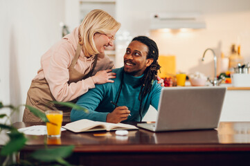 Obraz premium An Arabic happy course attendee is following an online course from home while his wife is supporting him.