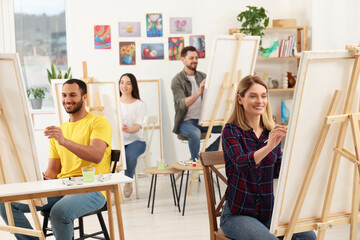Fototapeta na wymiar Group of students attending painting class in studio. Creative hobby
