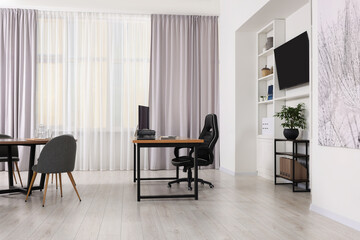 Stylish director's workplace with comfortable furniture and tv zone in room. Interior design