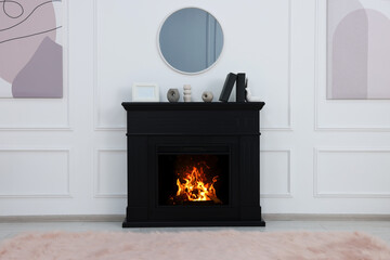 Black stylish fireplace with accessories under round mirror in cosy living room