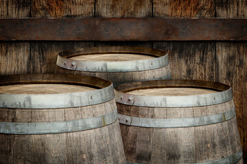 Fototapeta premium Three wooden barrels near old textured wall