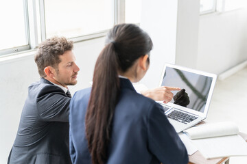 学校・塾でノートパソコンを使って勉強する高校生・中学生と外国人講師・先生・教師の後ろ姿（ICT教育）
