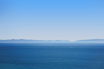 Hazy Ocean view with a boat in the distance - 621423441