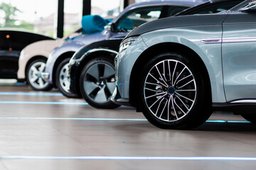 Beautiful Car dealership showroom interior with brand new vehicles for sale. White floor for new...
