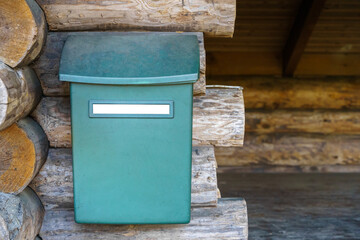 Mailbox with empty white label outside the wooden lean-to shelter