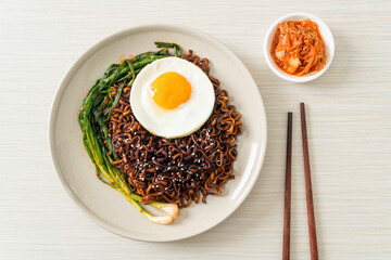 dried Korean spicy black sauce instant noodles with fried egg and kimchi