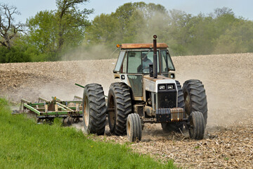 old tractor pulling a cultivator