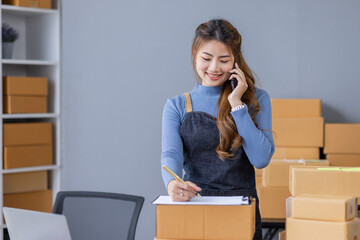 Portrait of Asian young woman SME working with a box at home the workplace.start-up small business owner, small business entrepreneur SME or freelance business online and delivery concept.
