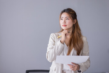 Boring young business Asian woman holding document file and looking at camera stand on a studio...