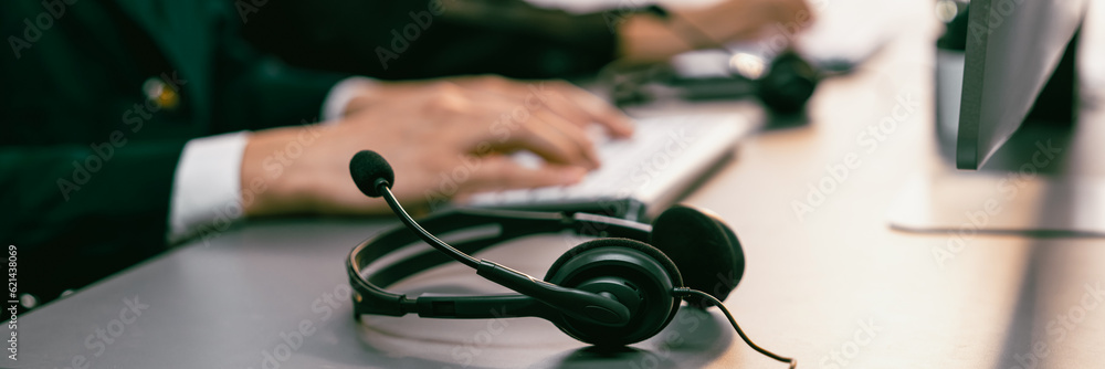 Aufkleber panorama focus headset on call center workspace desk with blur background of operator team or telesa
