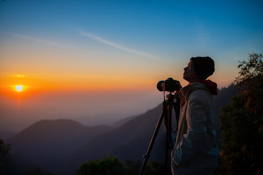 Silhouette Photographer take a landscape photo at twilight sunrise