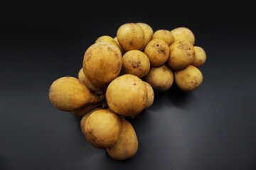 Long gong fruit or lansium parasiticum isolated on black background.