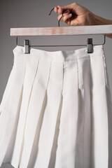 Mockup white pleated skirt, teenager girl school uniform on neutral gray background. Mock up