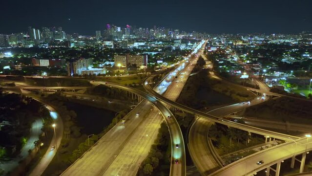 Above view of wide highway crossroads in Miami, Florida at night with fast driving cars. USA transportation infrastructure concept
