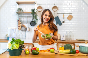 Portrait of beauty body slim healthy asian woman having fun cooking and preparing cooking vegan food healthy eat with fresh vegetable salad on counter in kitchen at home.Diet.Fitness, healthy food