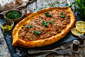 Turkish pide - Turkish flatbread pizza with minced meat on wooden background
