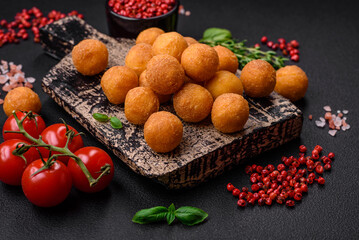 Delicious fried potato balls with breaded mozzarella, salt, spices and herbs