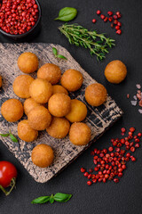 Delicious fried potato balls with breaded mozzarella, salt, spices and herbs