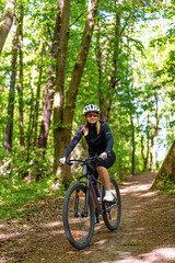Fototapeta na wymiar Woman riding bicycle in forest 