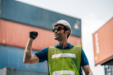 Portrait of Smiling Professional Heavy Industry Engineer  Worker Wearing Safety Uniform and Hard Hat. In the Background container Industrial Factory shipment