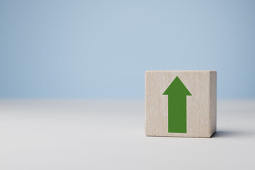 Green increasing up arrow on wooden cube block. business investment growth concept. Business...